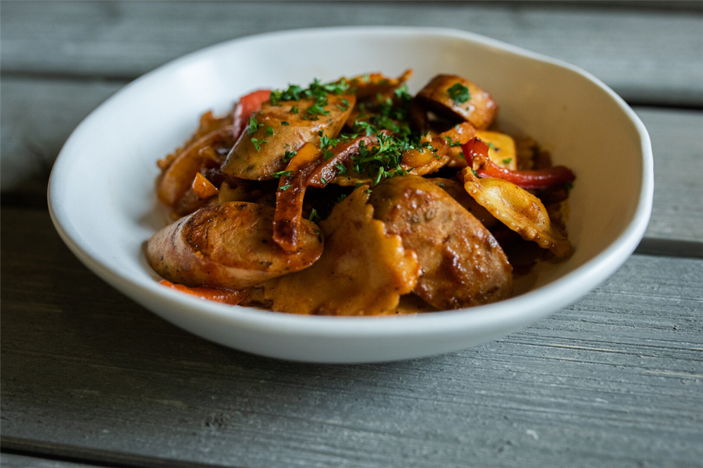 Fresh ravioli with sausages and bell peppers